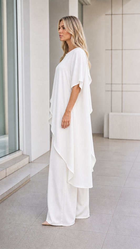 Model wearing white pant set, side profile view