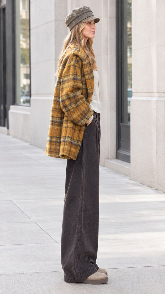Side view of model in mustard yellow plaid button-down lapel coat