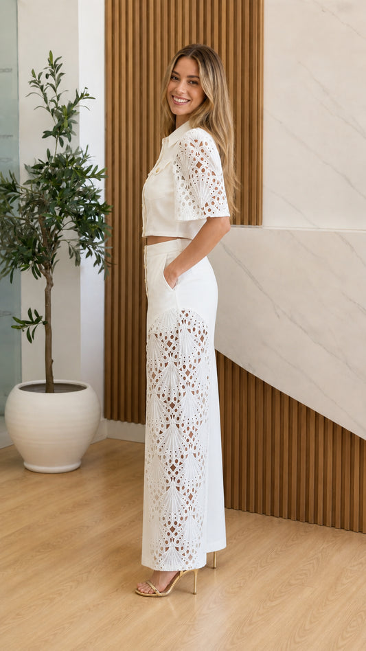 Side profile of model wearing white two-piece set with wide leg cutouts