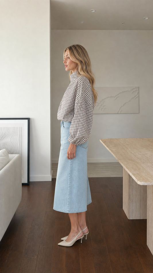Side profile of model wearing white plaid high-neck blouse