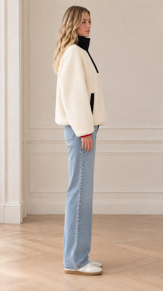 Side profile view of model wearing cream fleece pullover sweatshirt