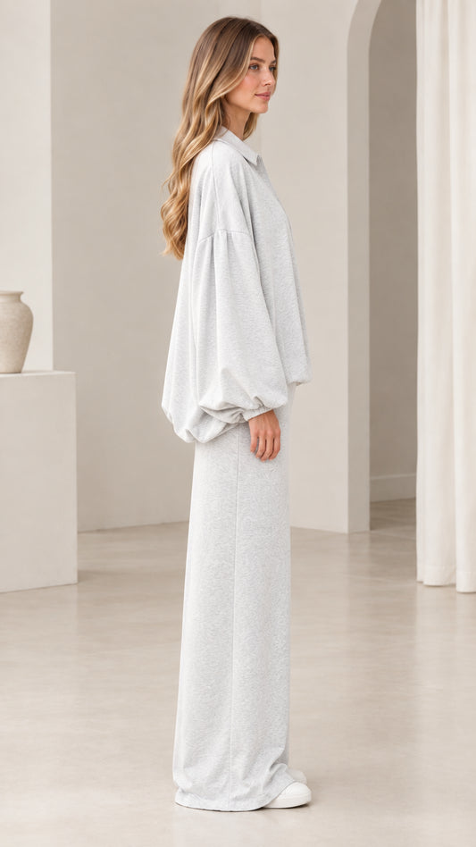 Side profile view of model wearing heather grey two-piece jacket and skirt set