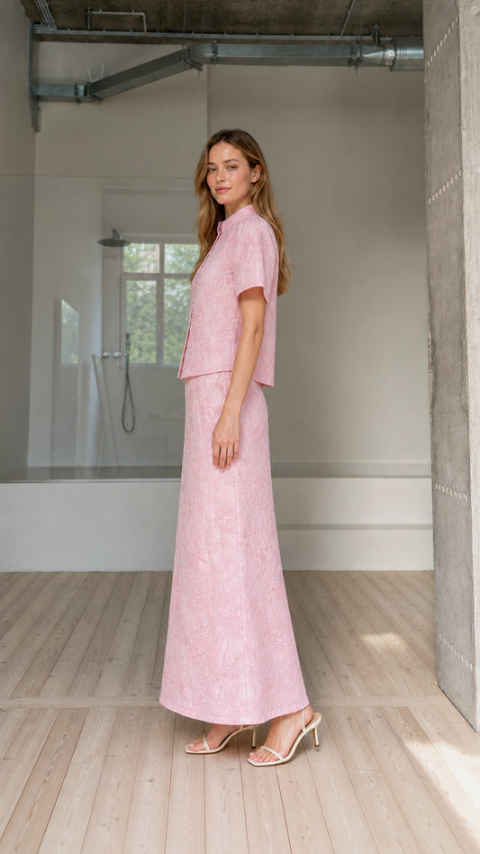 Side view of model wearing pink embroidered two-piece blouse and maxi skirt set