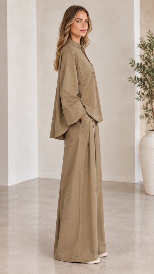 Side profile view of woman modeling khaki matching long-sleeve top and flowy trousers