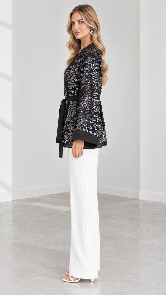 Side angle of model in Black sequin wrap cardigan showing sleeve and waist tie detail
