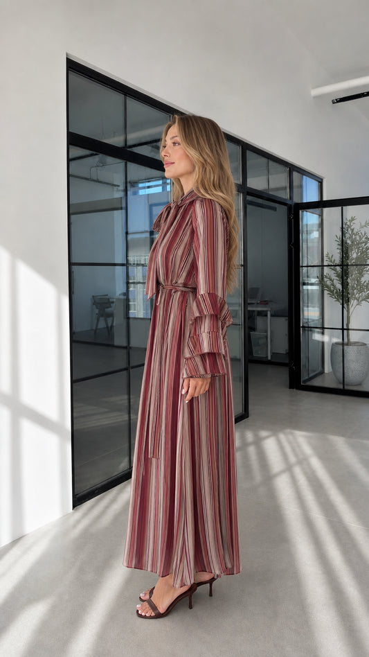 Model wearing burgundy striped maxi dress side profile