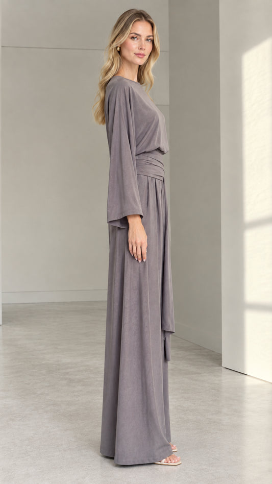 Side profile view of woman wearing a slate grey fluid wide-leg jumpsuit
