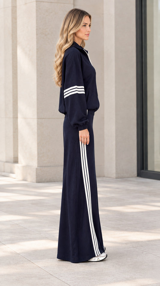Side profile of navy blue sporty jacket and striped maxi skirt outfit