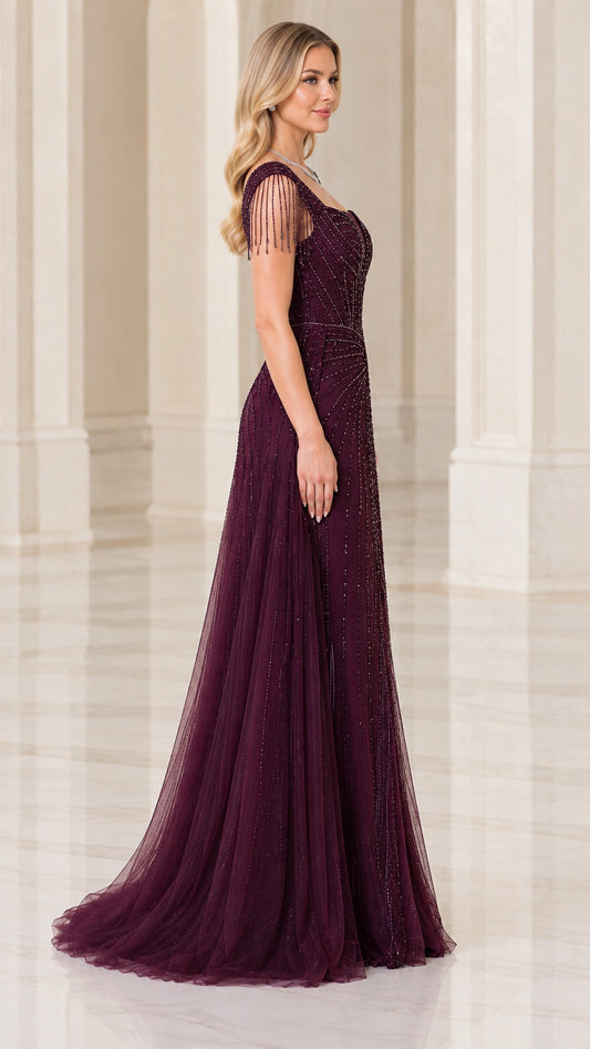 Side profile of burgundy beaded gown showing flowing tulle train and fringe sleeves