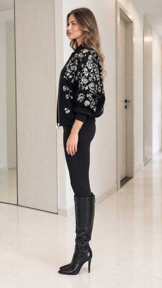 Side profile view of model wearing black embroidered bomber jacket