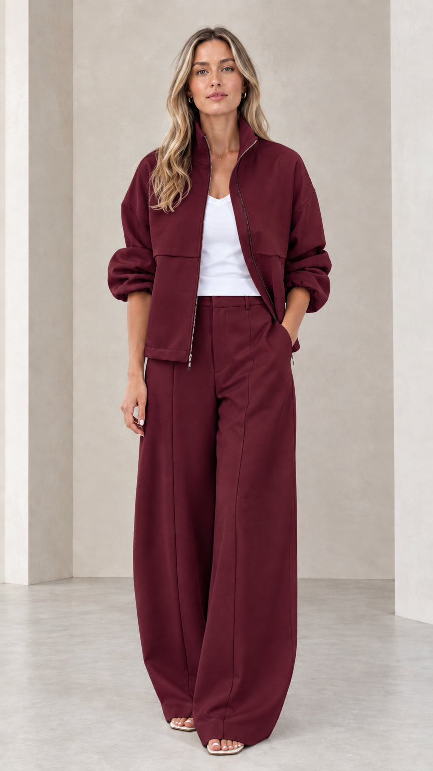 Full front view of women's burgundy zip-up jacket and wide-leg pants two-piece set