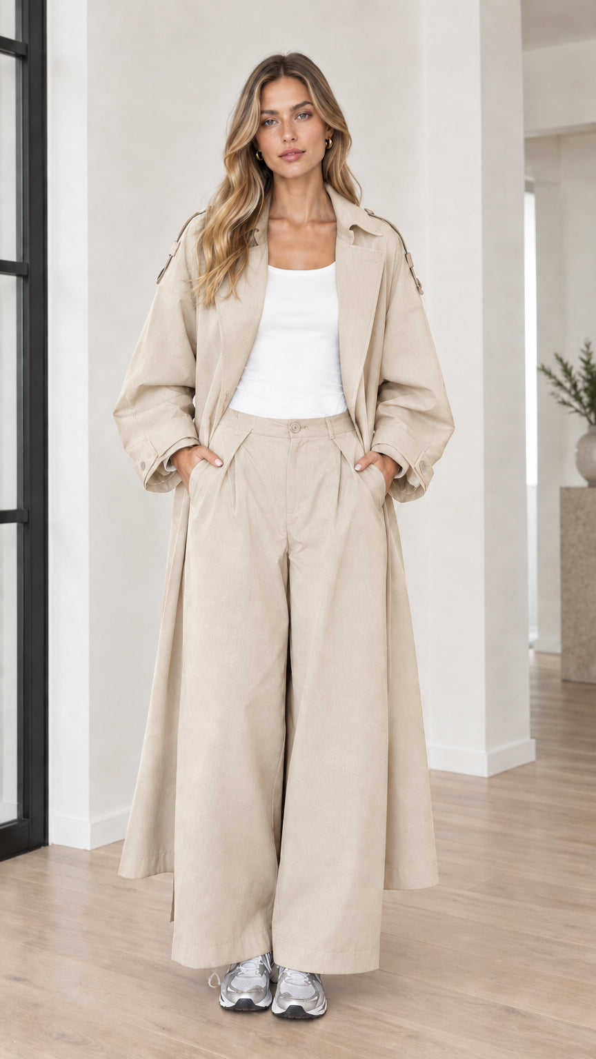 Woman wearing light beige cream oversized maxi trench coat and wide-leg trousers set