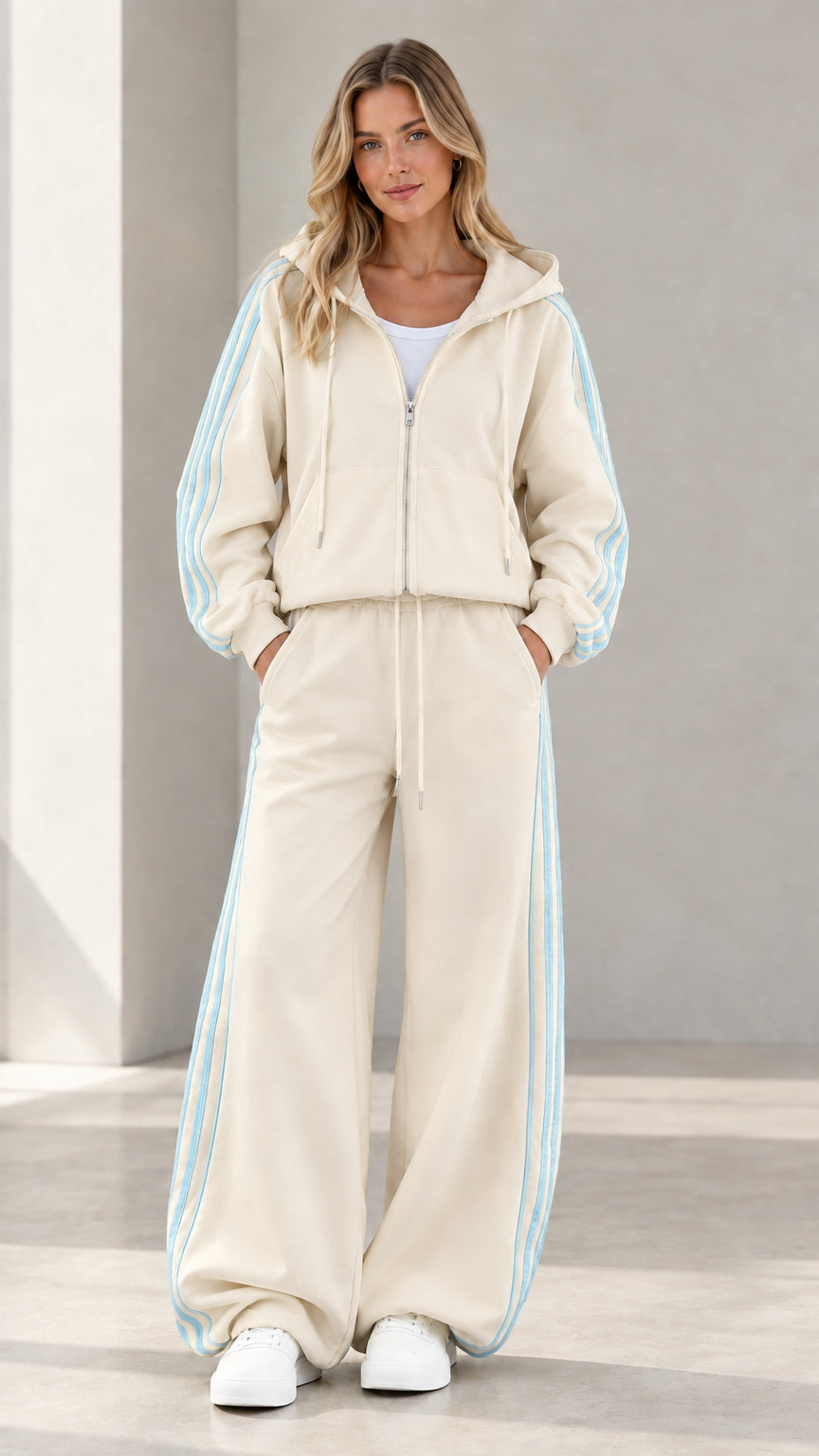 Model wearing cream beige two-piece tracksuit set with striped details