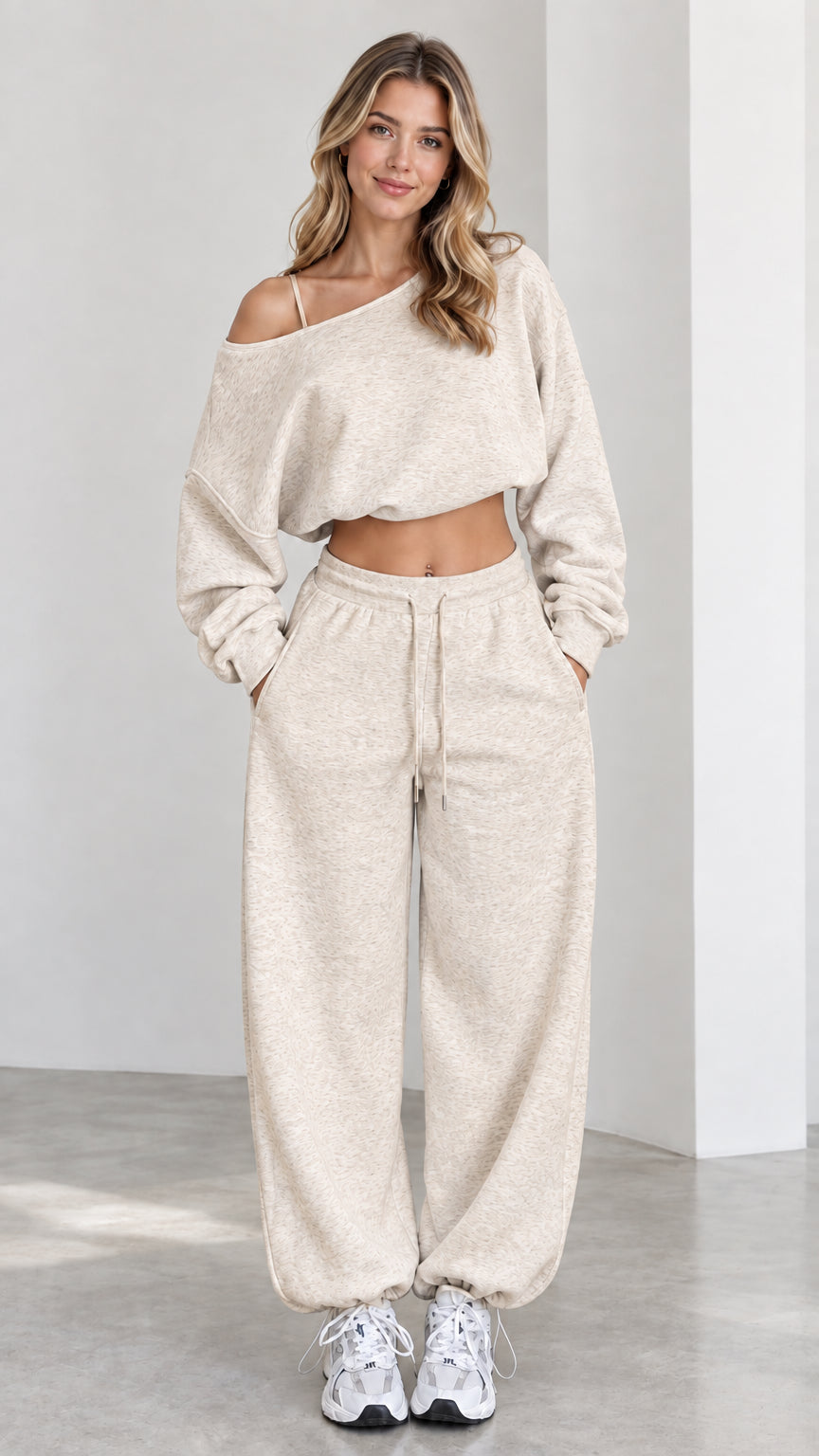 Model wearing oatmeal cream one-shoulder cropped sweatshirt and wide-leg track pants set