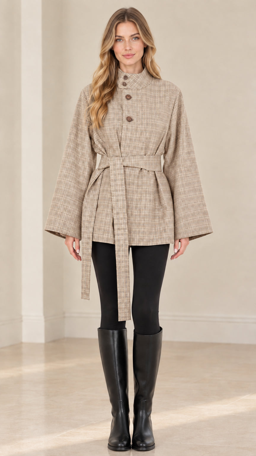 Front view of woman wearing beige plaid belted cape jacket