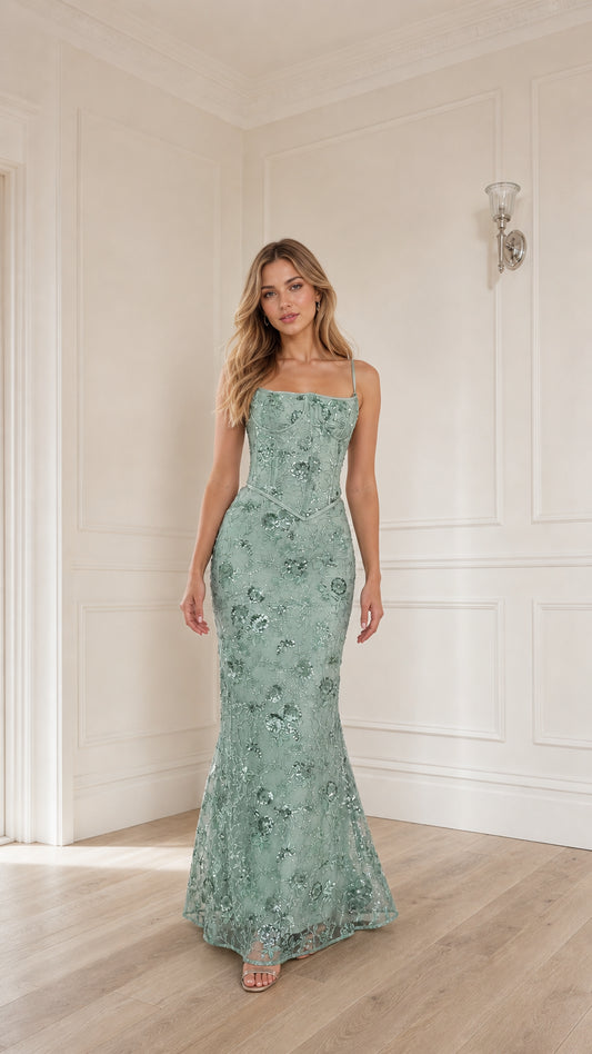 Woman wearing sage green sequin embroidered corset maxi dress, front view