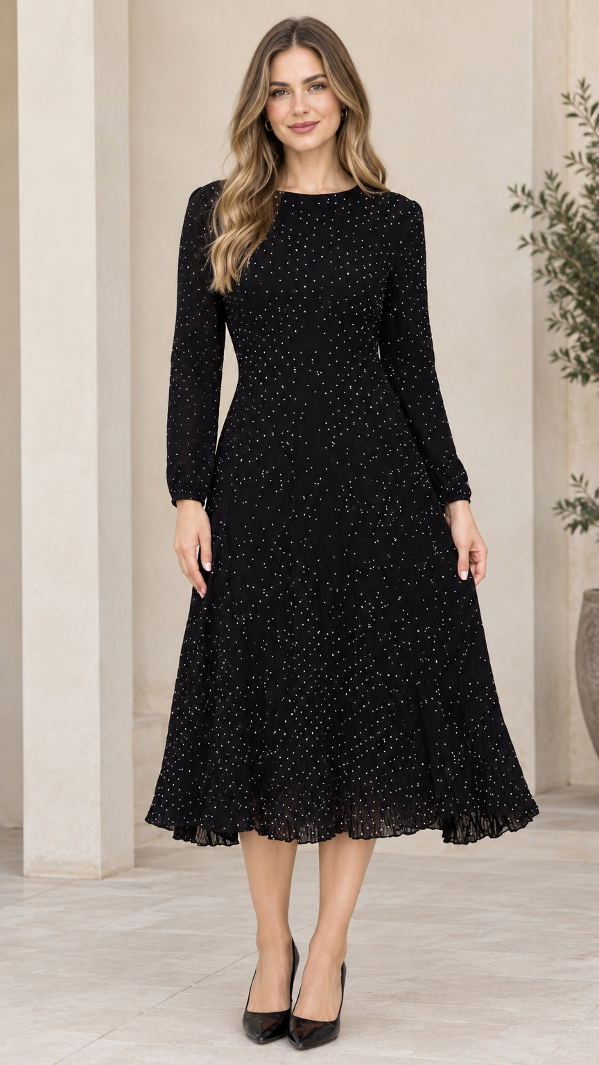 Front view of woman wearing black long sleeve micro dot A-line midi dress with pleated hem
