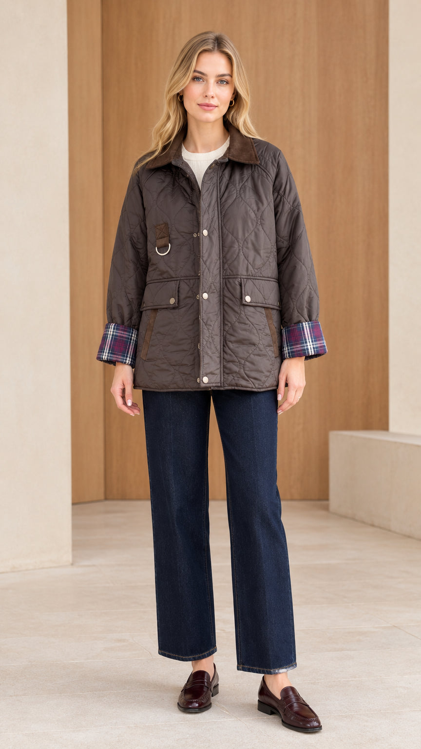 Front full view of woman wearing dark brown diamond quilted barn jacket with jeans and loafers