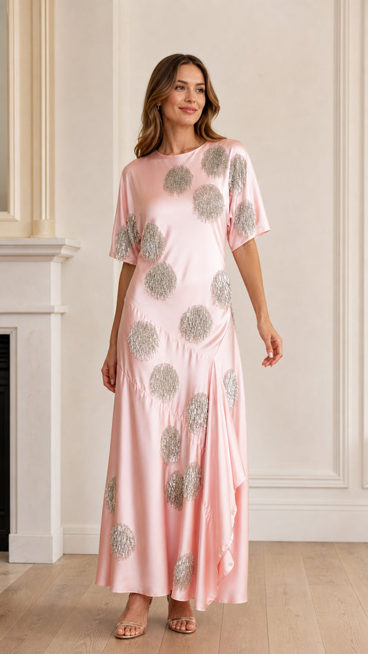 Front view of model wearing pink sequin polka dot satin maxi dress