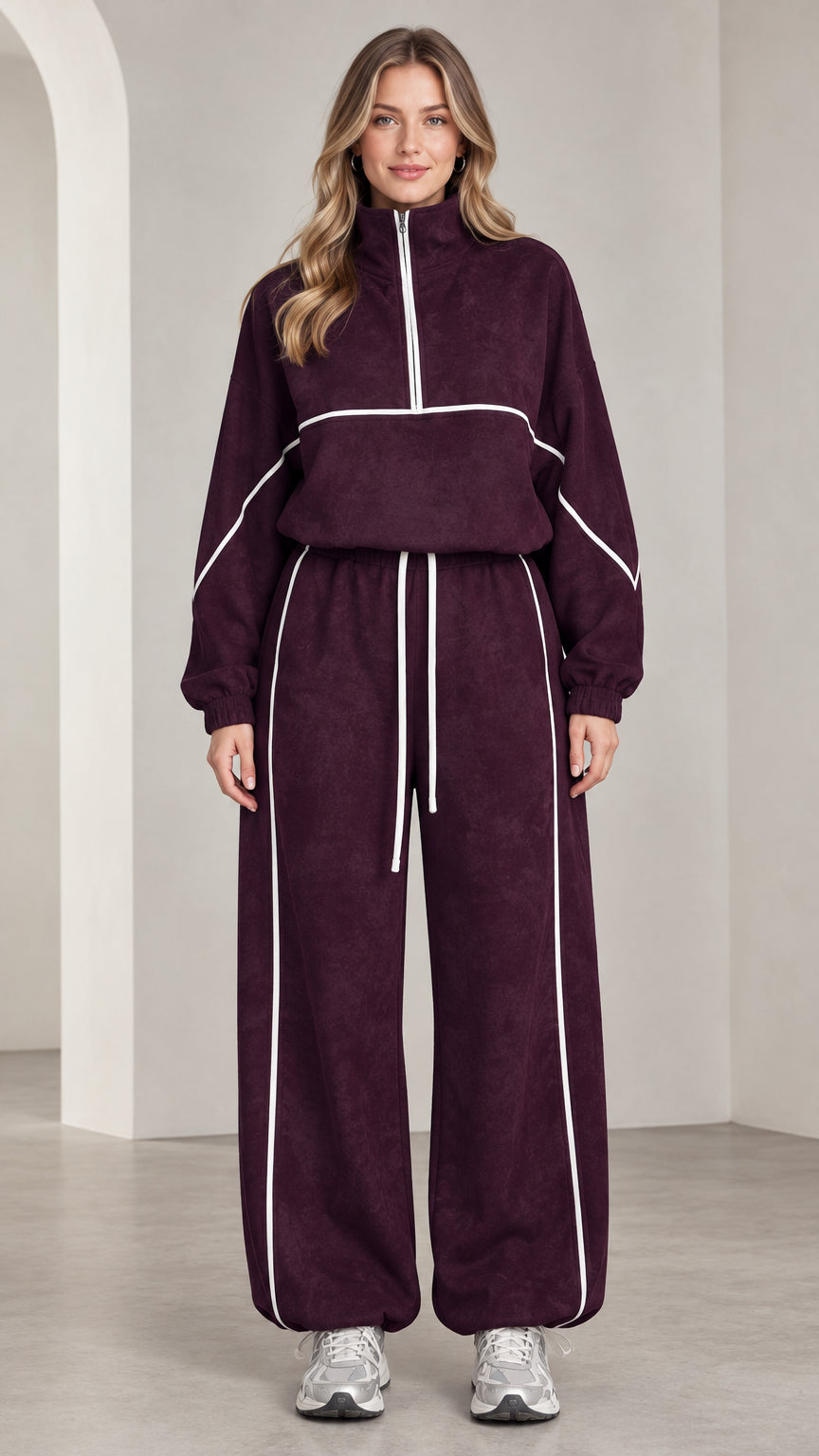 Front view of woman wearing burgundy quarter-zip tracksuit set with white contrast piping