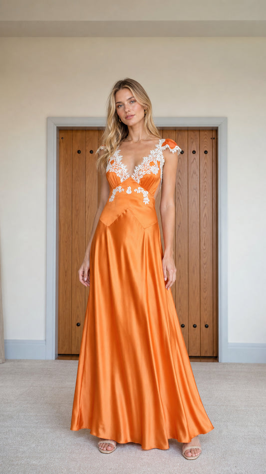 Front view of model wearing orange satin maxi dress with white lace