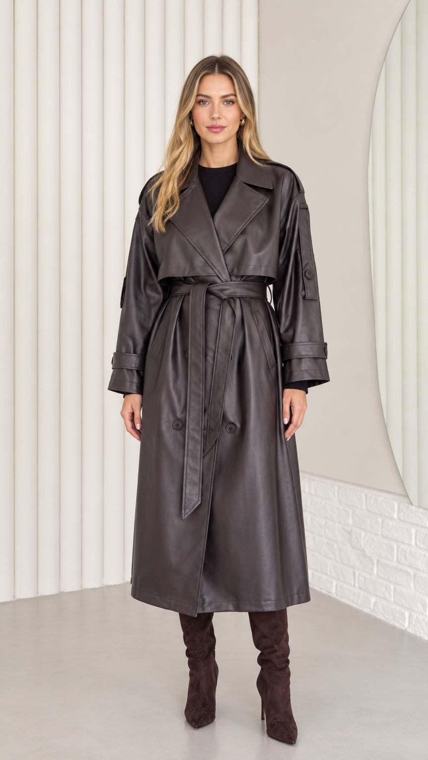 Full-length front view of woman wearing dark brown faux leather belted trench coat