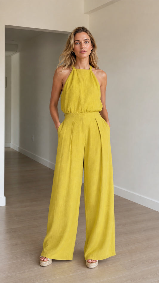 Model wearing yellow halter neck wide-leg jumpsuit front view