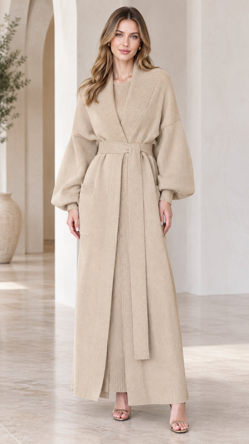 Front view of woman wearing beige maxi knit duster cardigan and matching dress set with belt