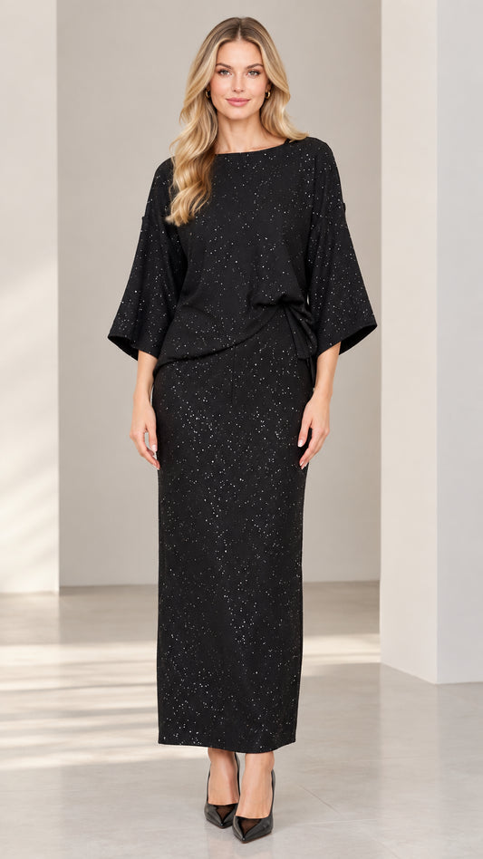 Front full-length view of woman wearing black sparkle boat neck top and maxi column skirt set