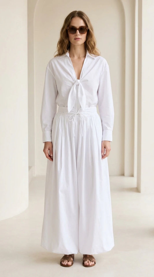 Woman wearing white tie-front shirt and wide-leg pants set, front view
