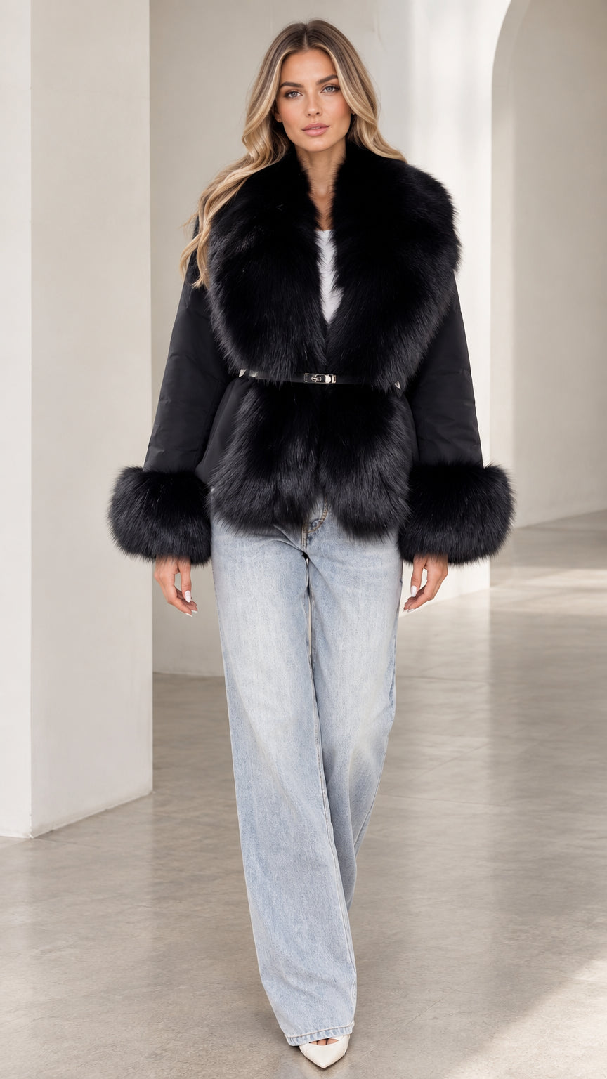 Front view of model wearing black belted jacket with plush faux fur collar and cuffs