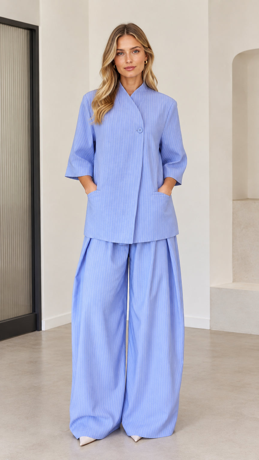 Women's light blue pinstripe two-piece set featuring asymmetric top and wide-leg pants front view