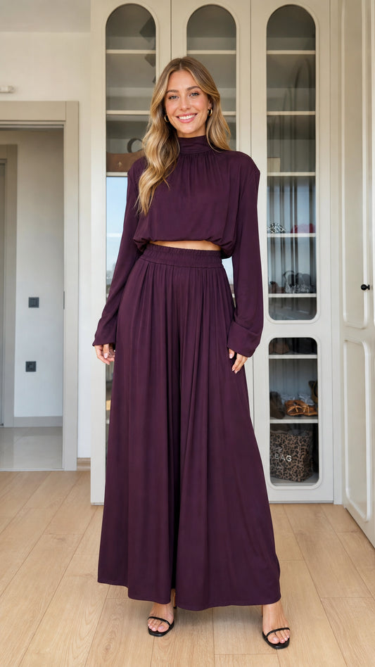 Front full-length view of woman wearing plum mock neck crop top and matching pleated wide-leg pants