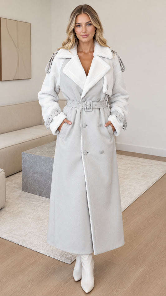 Front view of woman wearing light grey faux shearling maxi trench coat with belt
