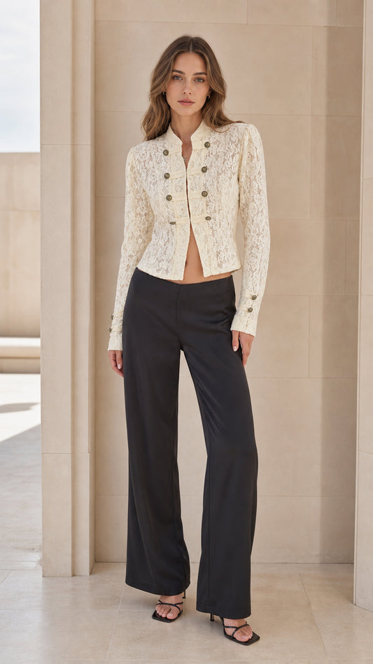 Front full view of woman wearing ivory lace military jacket with black trousers