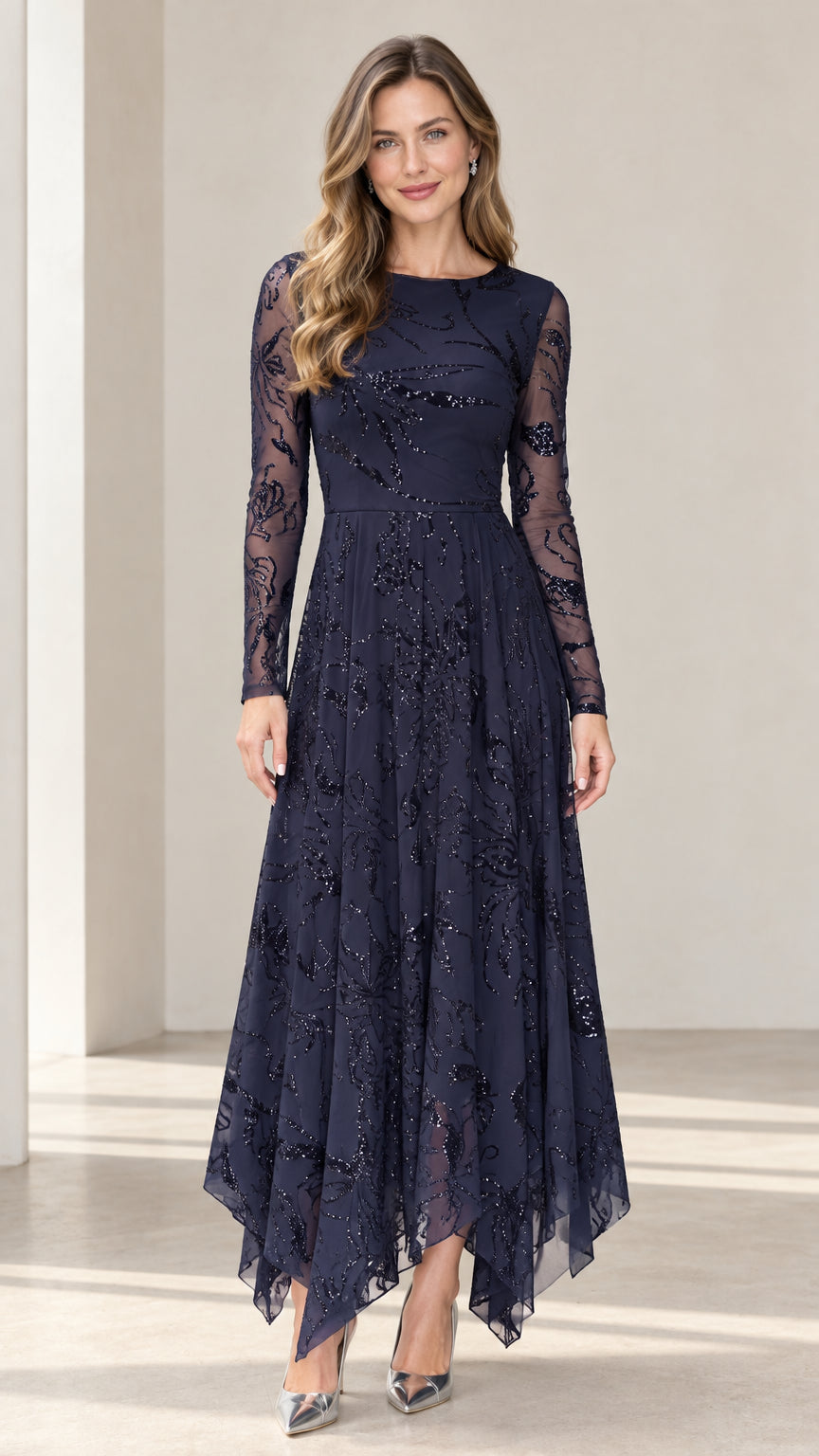 Front view of woman wearing navy blue sequin embroidered long sleeve evening dress with handkerchief hem