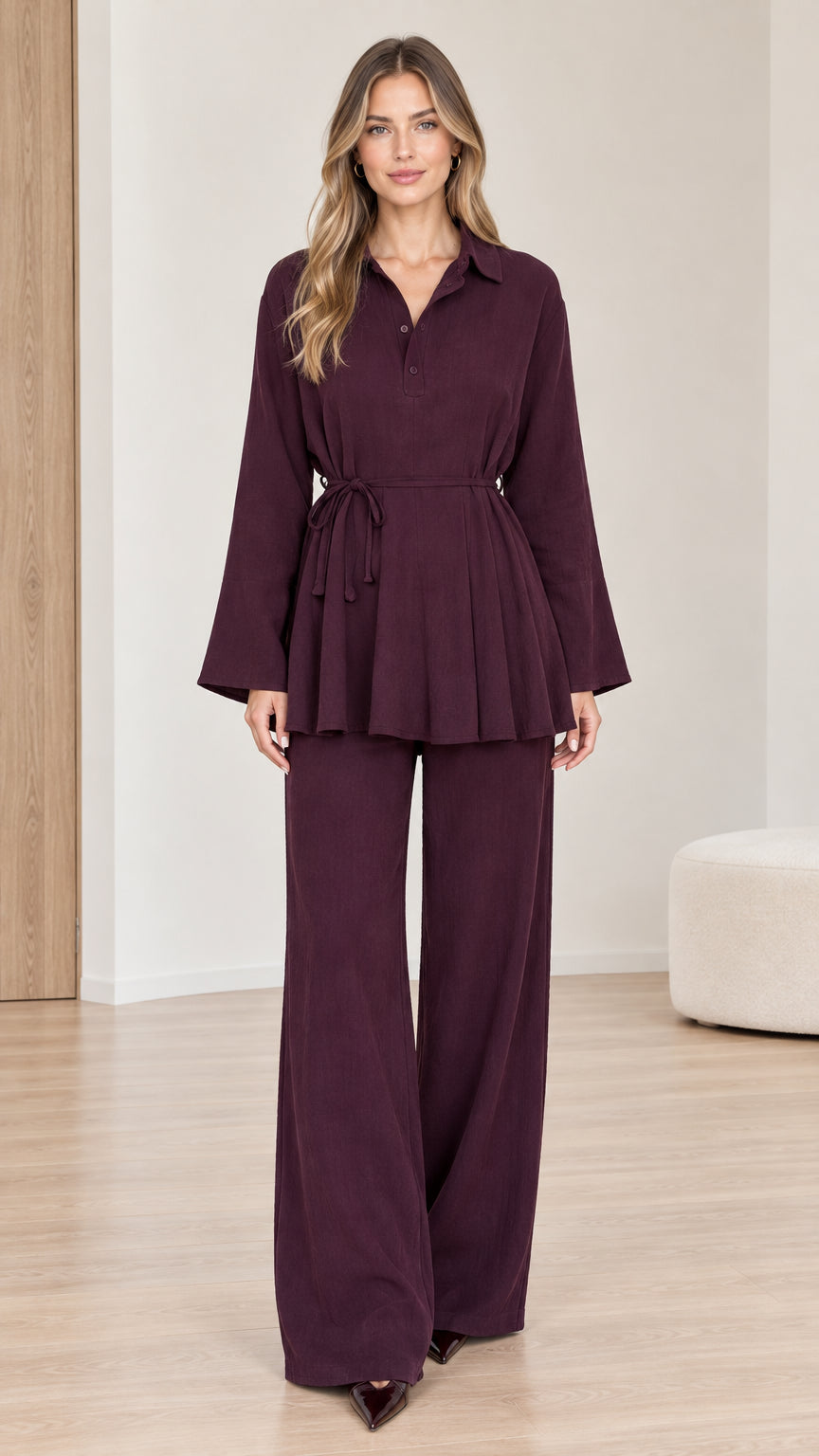 Front full view of woman wearing burgundy belted peplum tunic and wide-leg trousers two-piece set