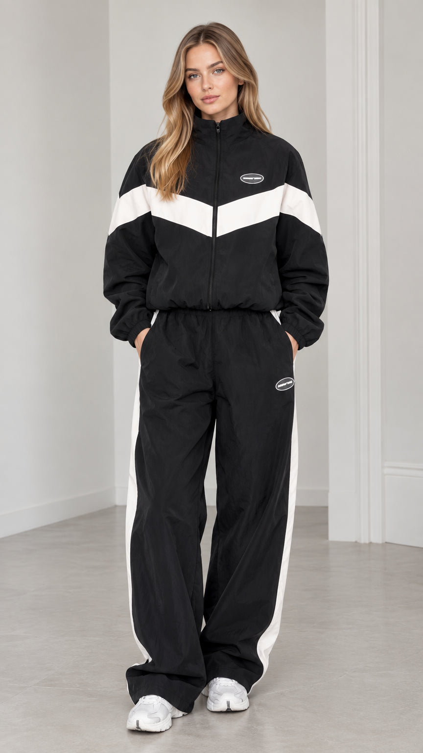 Front view of woman wearing black and white chevron colorblock tracksuit set with wide leg pants