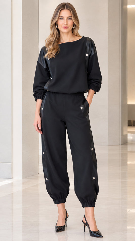 Full front view of women's black boat neck top and snap button jogger set