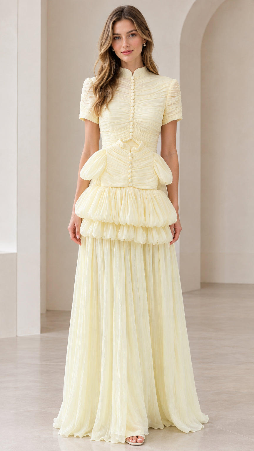 Front view of model wearing pale yellow mock neck tiered pleated maxi dress