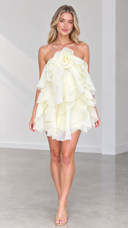 Full front view of model wearing Butter Yellow halter tiered ruffle mini dress with 3D rosette