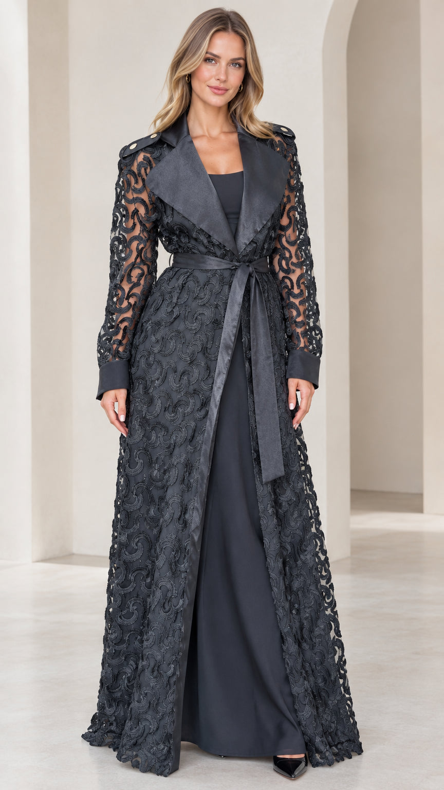 Front view of model wearing black floral lace maxi trench coat with satin lapels
