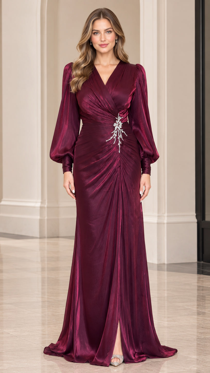 Front view of model wearing burgundy long sleeve ruched satin evening gown with crystal waist accent