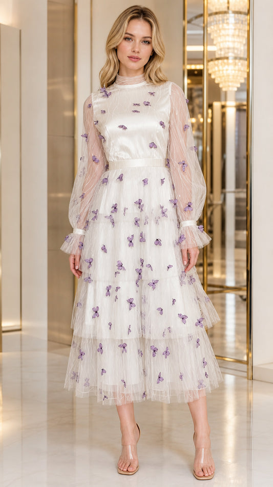 Front view of woman wearing ivory white tiered tulle midi dress with purple 3D butterflies