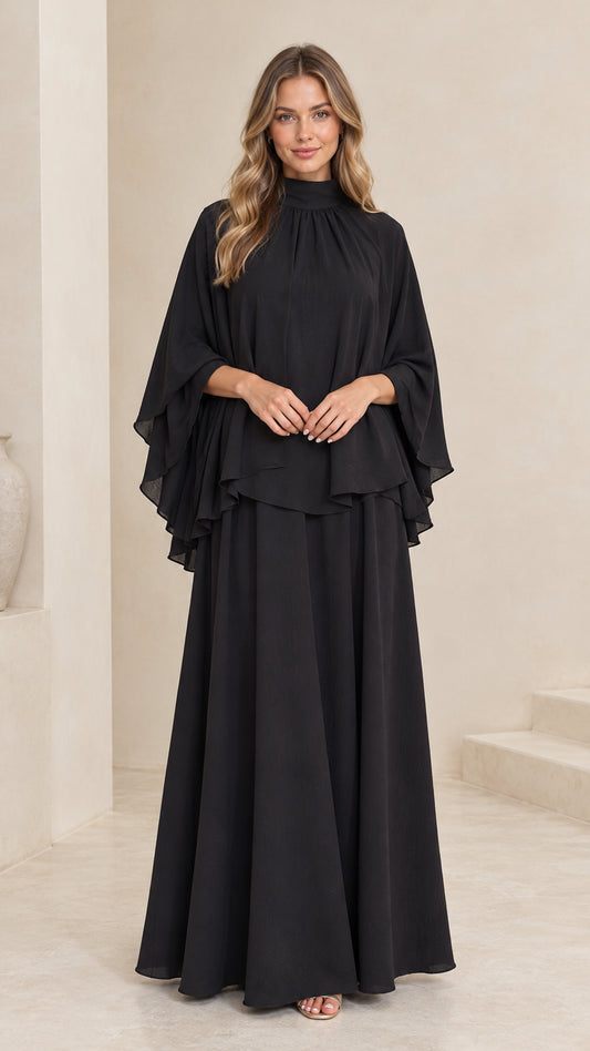 Front view of model wearing black mock neck cape overlay maxi dress