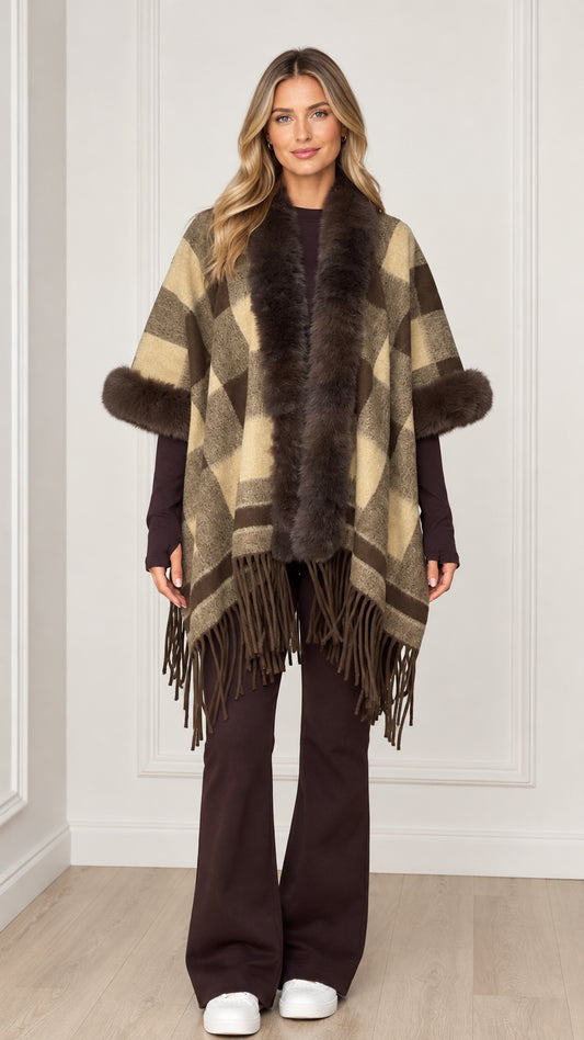 Woman wearing olive khaki plaid poncho with faux fur collar and fringe hem - front view