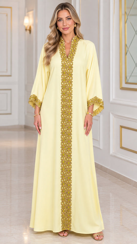 Front view of woman wearing pale yellow kaftan maxi dress with gold embroidered trim