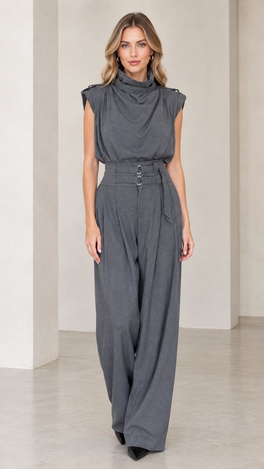 Front view of woman wearing a charcoal grey sleeveless drape high neck wide leg jumpsuit with belt