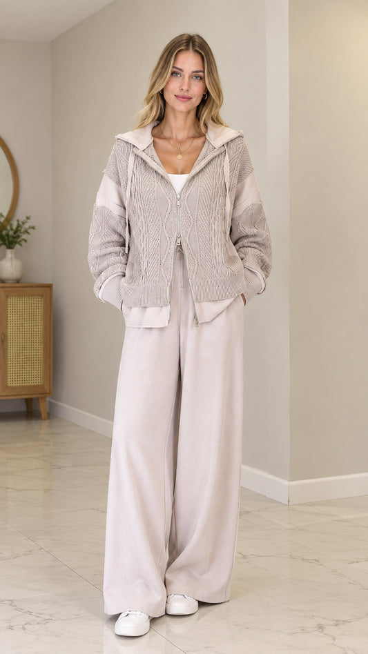 Front full view of model wearing Oatmeal cable-knit zip-up hooded cardigan with wide-leg pants