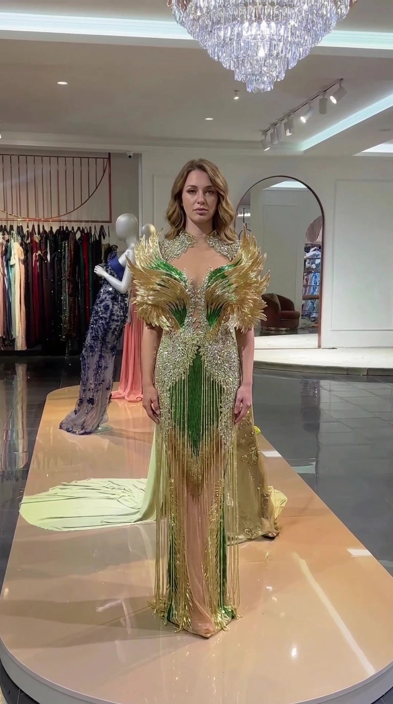 Full front view of emerald green and gold beaded evening gown with feathered shoulders